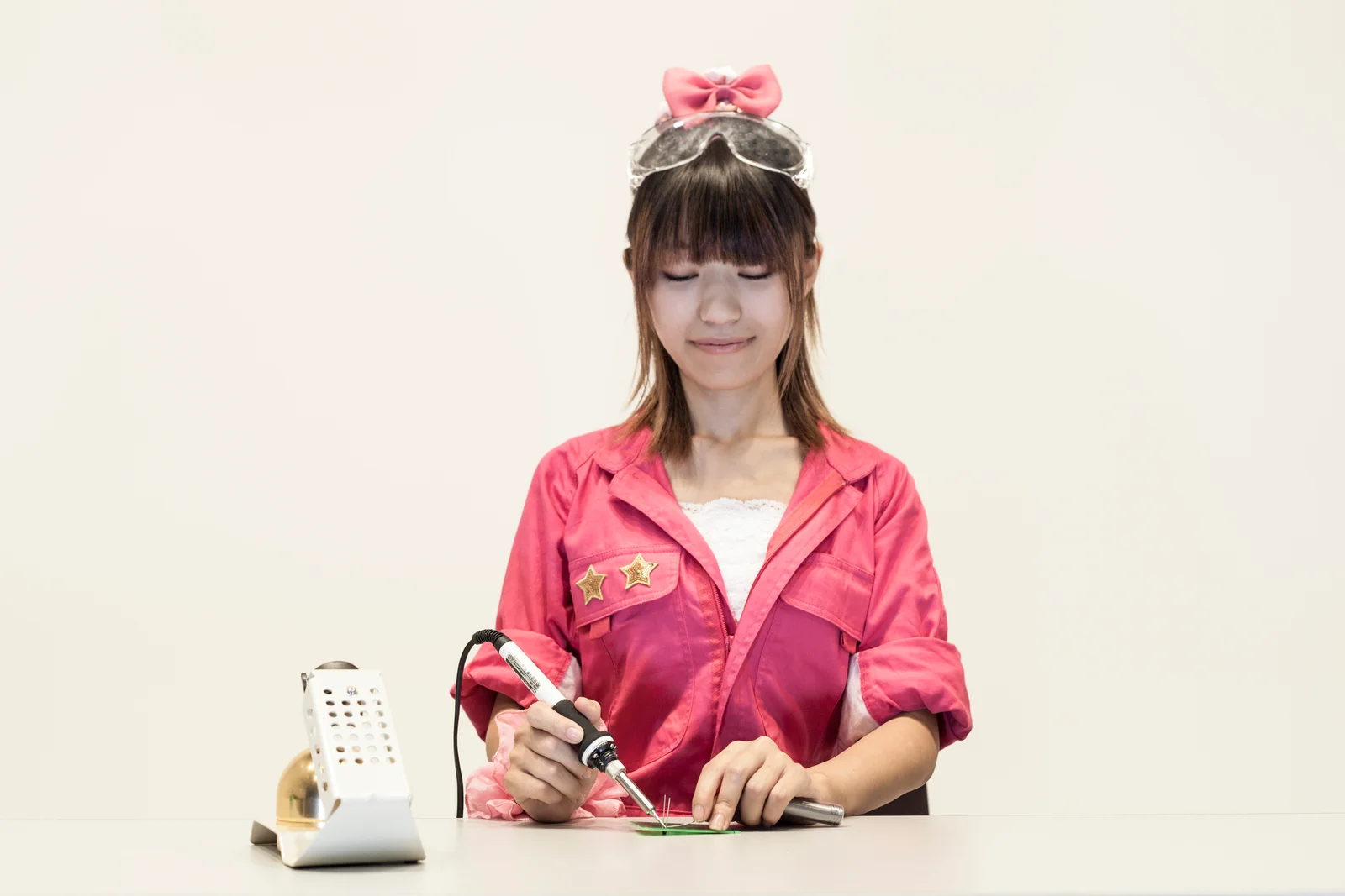 はんだごてを持ち、基板に向き合うあいんちゃん